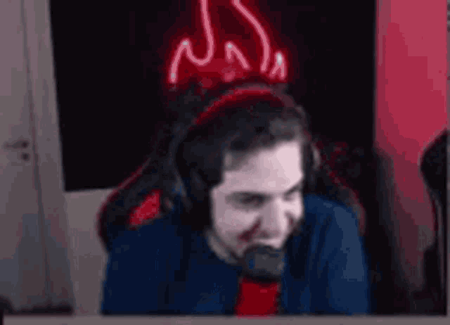 a man wearing headphones is sitting in front of a microphone and smiling .