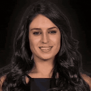 a close up of a woman 's face with long black hair smiling .