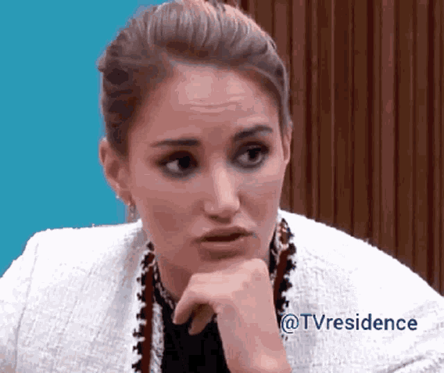 a woman with her hand on her chin and the words @tvresidence behind her