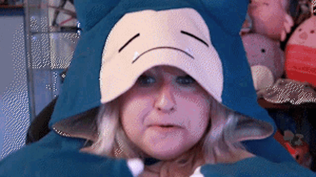 a woman is wearing a snorlax costume with a sad face