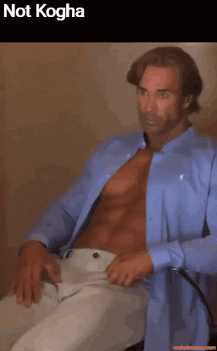 a man in a blue shirt is sitting in a chair with his shirt open