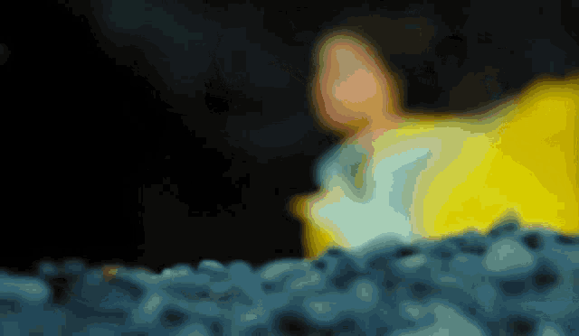 a blurred image of a person in a yellow jacket