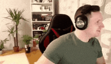 a man wearing headphones is sitting in a chair in front of a plant