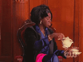 a woman is sitting in a chair with a teapot in her hand and the words new episode on the bottom right