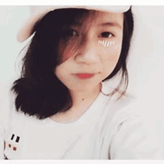 a young woman is wearing a hat and taking a selfie .
