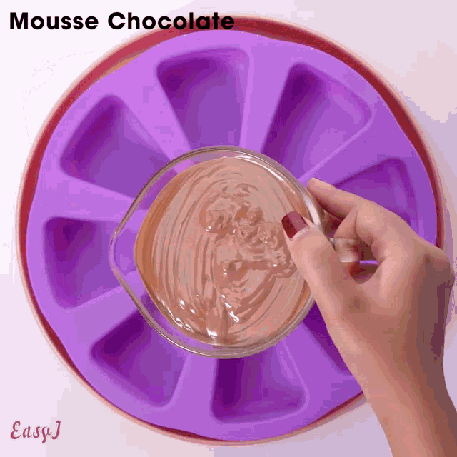 a person pouring mousse chocolate into a silicone mold