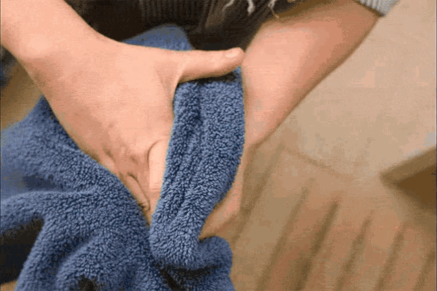 a person is holding a blue towel between their fingers