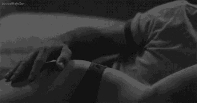a black and white photo of a man touching a woman 's belly .