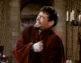 a man in a red robe is laughing with his hands on his hips