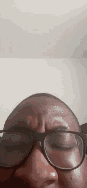 a close up of a person wearing glasses and making a funny face .