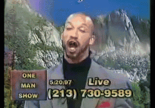 a man in a suit stands in front of a mountain and a sign that says live