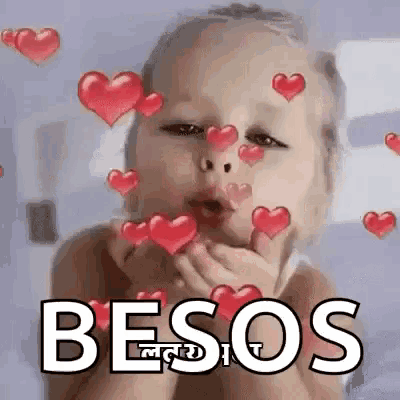 a baby is blowing a kiss with hearts surrounding it .