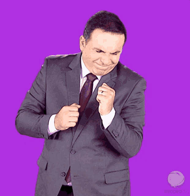 a man in a suit and tie is making a fist