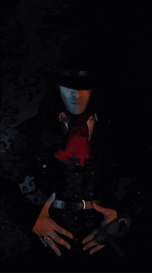 a woman in a black top hat with a red tie