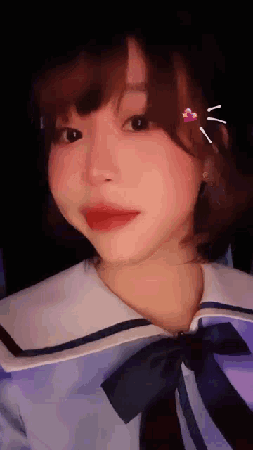 a close up of a girl 's face with a heart on her hair .