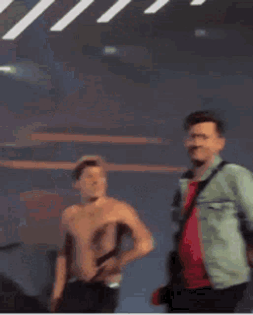 a shirtless man is dancing on a stage