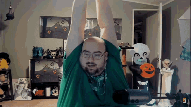 a man in a green shirt is stretching his arms in front of a microphone with the number 5 on it