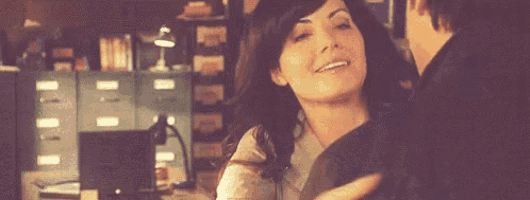 a woman is hugging a man in a room in a dark room .