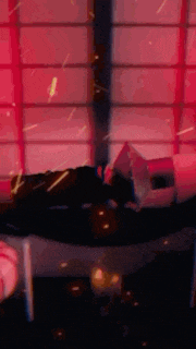 a person is laying on a bed in front of a window with a red light coming out of it .