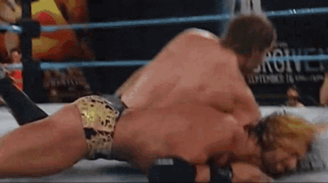 two men are wrestling in a wrestling ring and one of them is wearing leopard print shorts