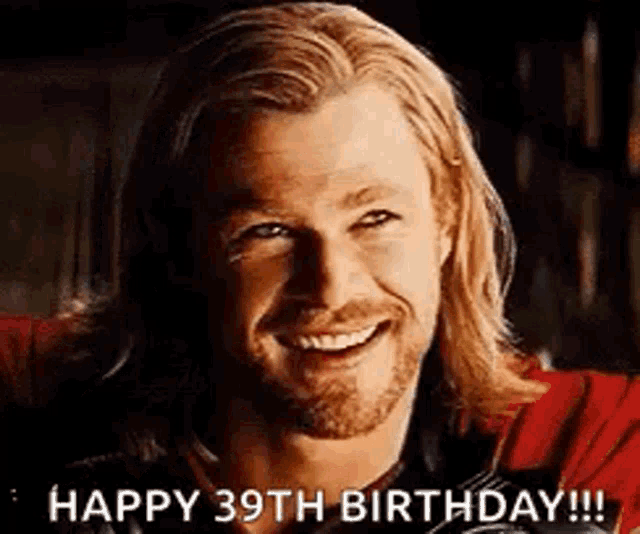 a man with long hair and a beard is smiling and says happy 39th birthday .