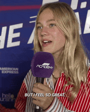 a woman speaking into a microphone that says academy
