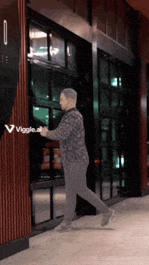 a man walking in front of a building with a viggle.ai logo