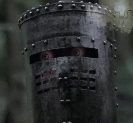 a close up of a knight 's helmet with a person 's eyes sticking out of it