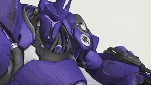 a close up of a purple robot with a logo on its chest