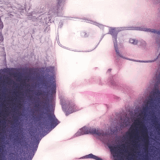 a man with glasses and a beard is thinking