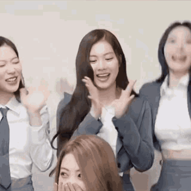 a group of young women are standing next to each other and laughing .