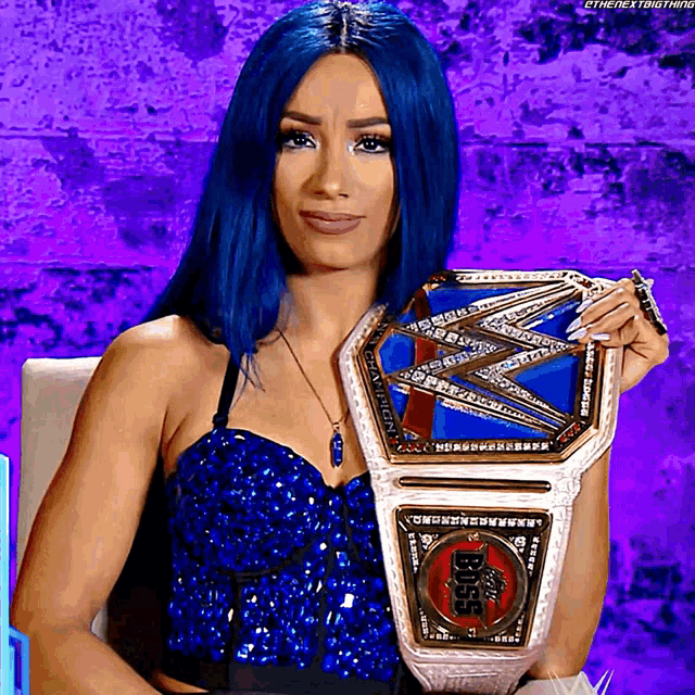 a woman with blue hair is holding a wrestling belt