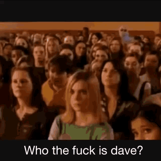 a crowd of people are sitting in a room with the words `` who the fuck is dave '' written on the bottom .