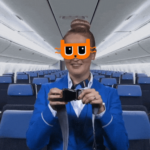 a stewardess wearing a cat mask takes a picture of herself in an airplane