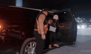 a man and a woman are getting out of a car with zeus written on the bottom