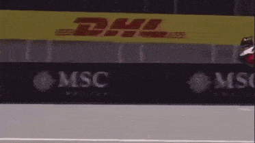 a race car is going down a track with a msc advertisement in the background