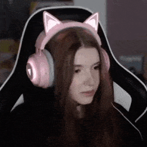 a girl is wearing a pair of pink cat ears headphones while sitting in a chair .
