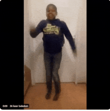 a young boy is dancing in front of a door in a hallway .