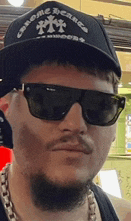 a man with a beard is wearing sunglasses and a hat .