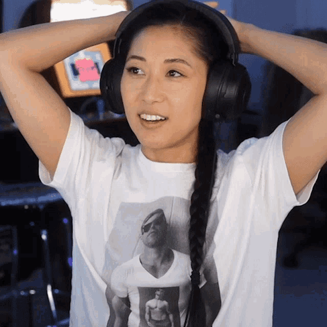 a woman wearing headphones and a t-shirt with a picture of a man on it