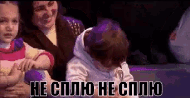 a woman is holding a child in her arms and the child is crying in a foreign language