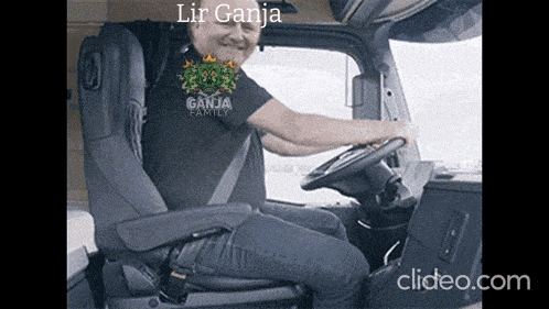 a man is sitting in the driver 's seat of a truck wearing a ganja family shirt