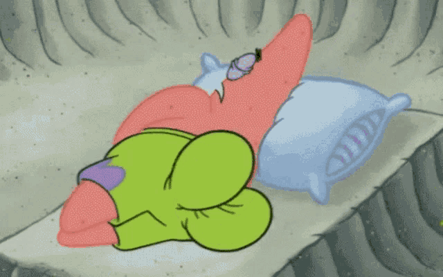 patrick star from spongebob squarepants is sleeping on a bed with two pillows .