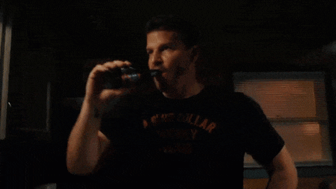 a man in a black shirt drinking from a can