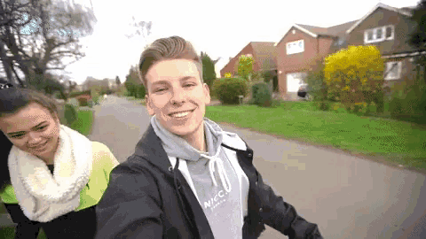 a man wearing a niccu jacket is taking a picture of himself and a woman