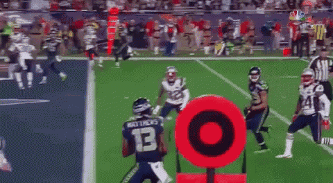 a football game is being played on a field with a red target in the foreground