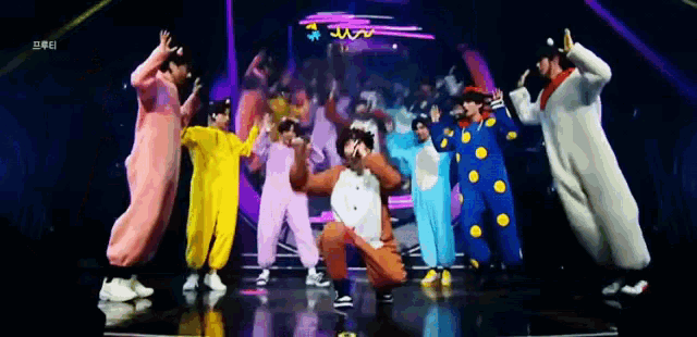 a group of people in costume are dancing on a stage with a neon sign in the background