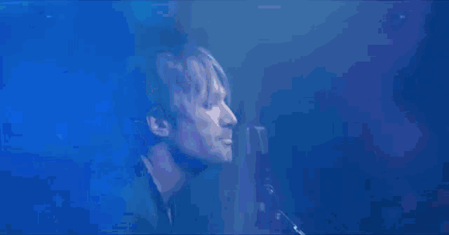 a man is standing in front of a blue light