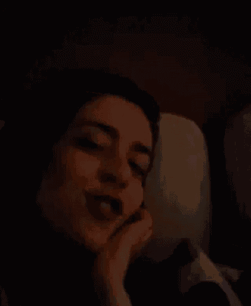 a woman is smiling while laying in bed with a stuffed animal