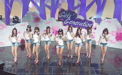 a group of girls are performing on a stage with a sign that says girl 's generation